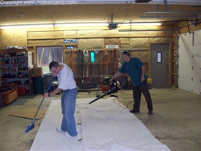 Sweeping the outside of the tent as it is folded